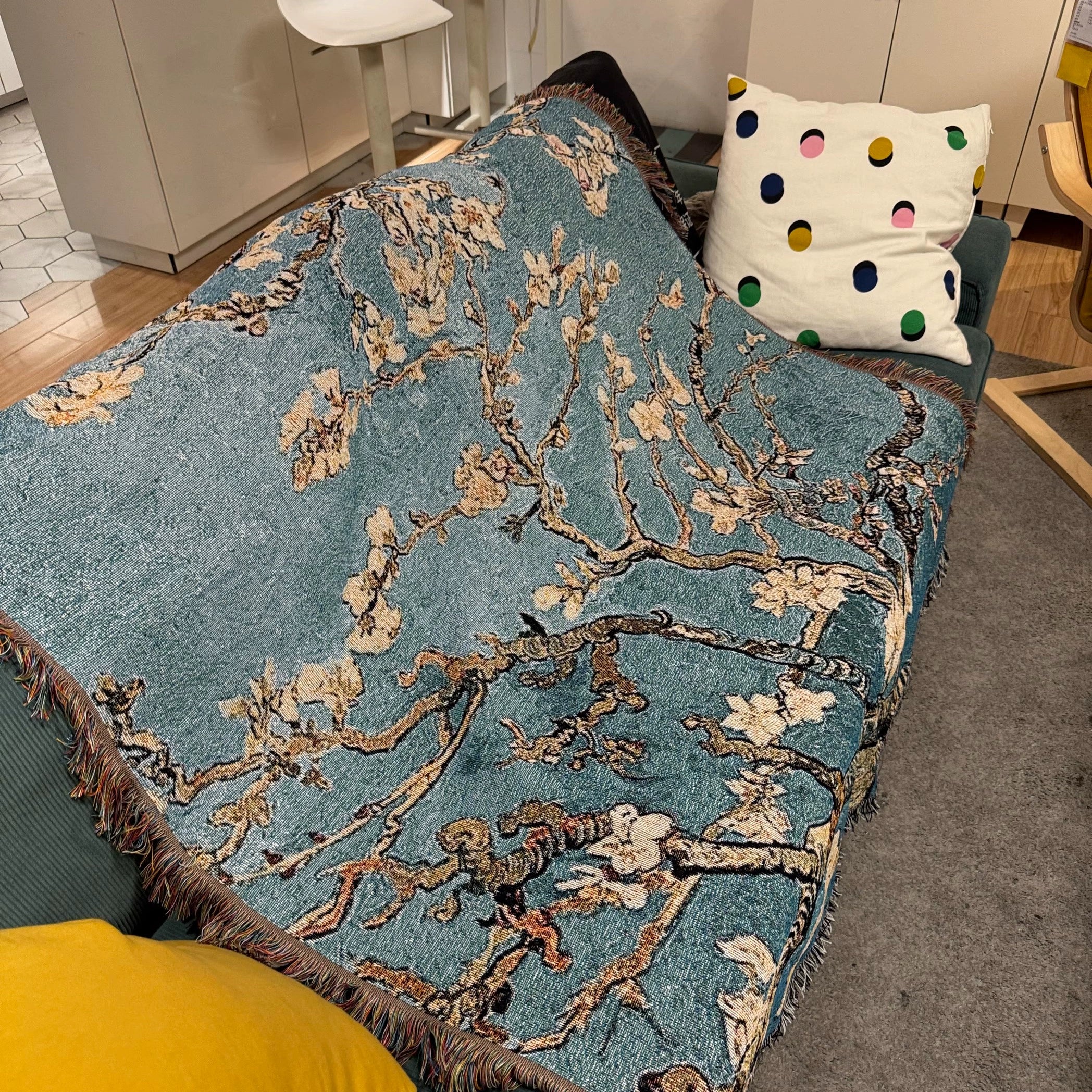 Floral patterned throw blanket on a couch with a polka dot pillow in the background.